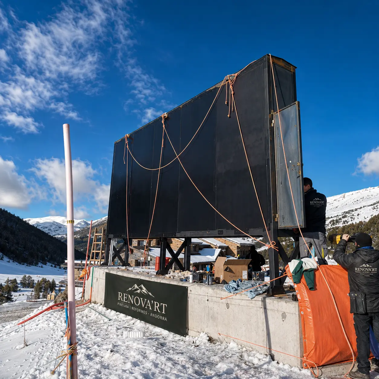 Equip de Renova'rt treballant en una gran estructura negra sobre la neu en alta muntanya d'Andorra